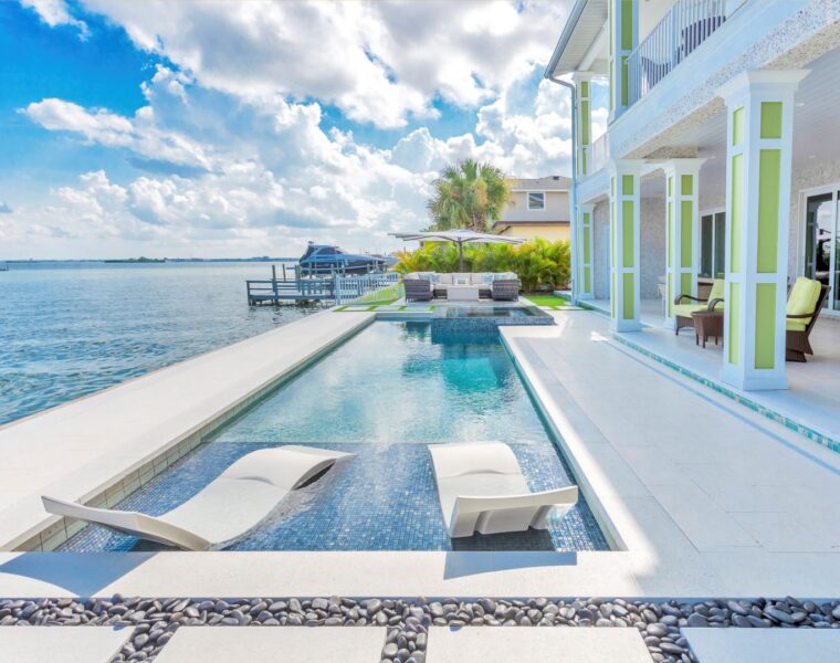 back patio with a pool on the water